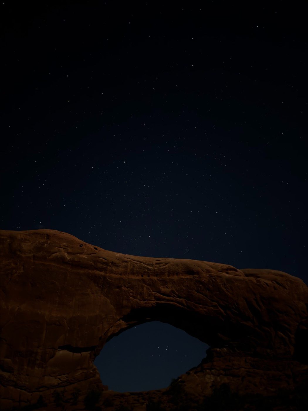 Night sky over a natural rock arch
